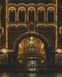 Night view of the illuminated facade of Moscow's iconic State Department Store, featuring ornate architecture.